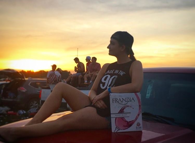 Woman enjoying Franzia wines at a tailgate